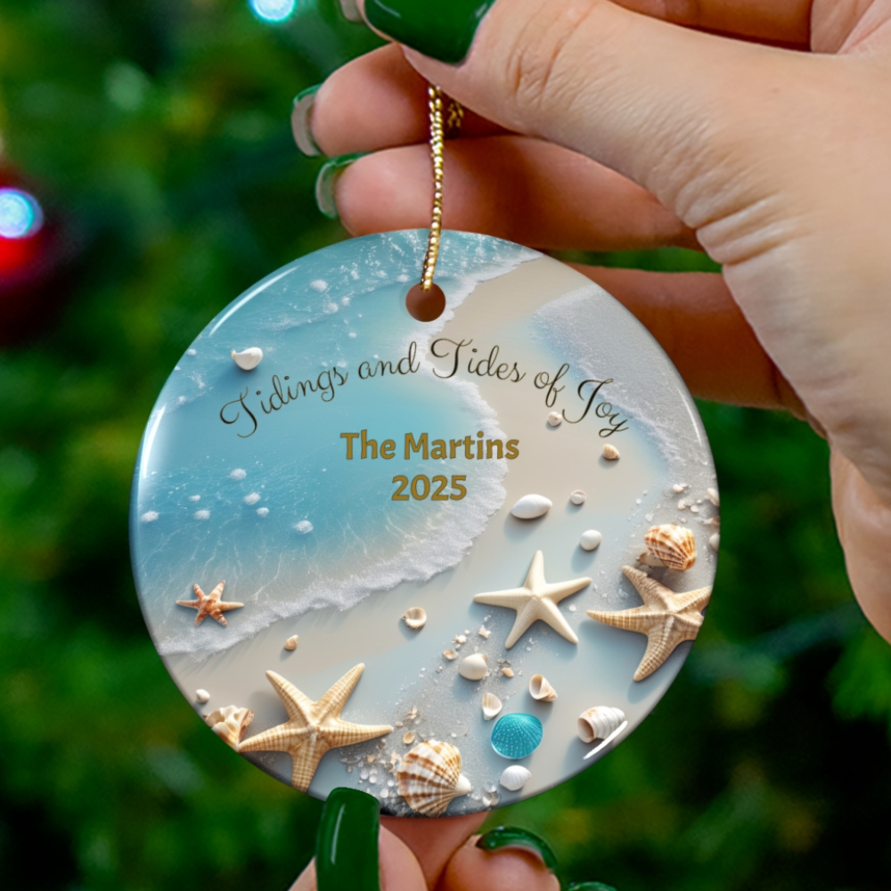 Decorative ornament with beach scene and personalized text held by a hand against a blurred green background.