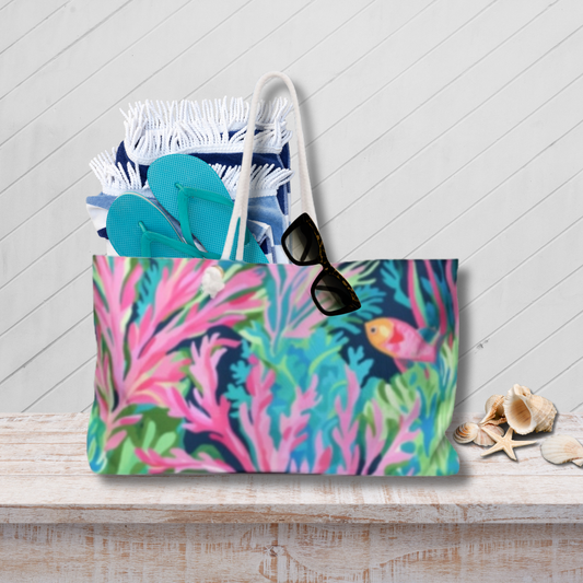 Colorful tote bag with floral design, sunglasses, and flip-flops on a wooden surface.