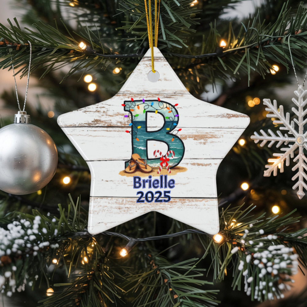 Christmas ornament with 'B' and 'Brielle 2025' on a star-shaped wooden plaque, hanging on a decorated tree.
