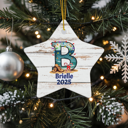 Christmas ornament with 'B' and 'Brielle 2025' on a star-shaped wooden plaque, hanging on a decorated tree.