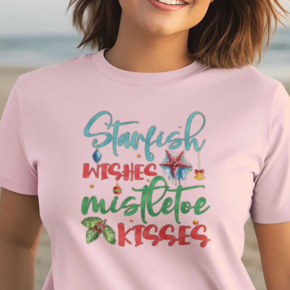 Person wearing a pink t-shirt with Christmas-themed text on a beach.