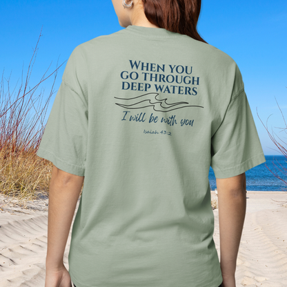 Person wearing a green t-shirt with a motivational quote on the beach