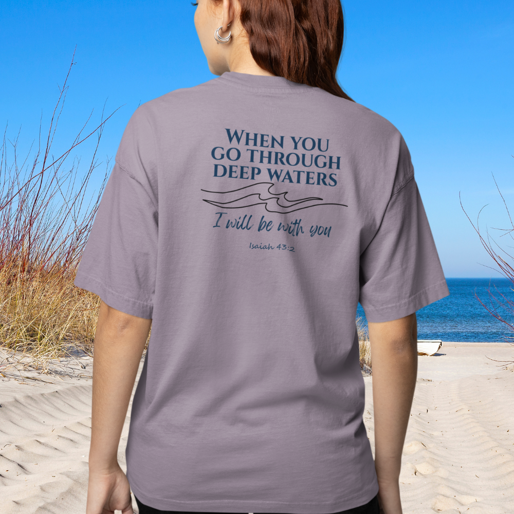 Person wearing a gray t-shirt with a motivational quote on the beach