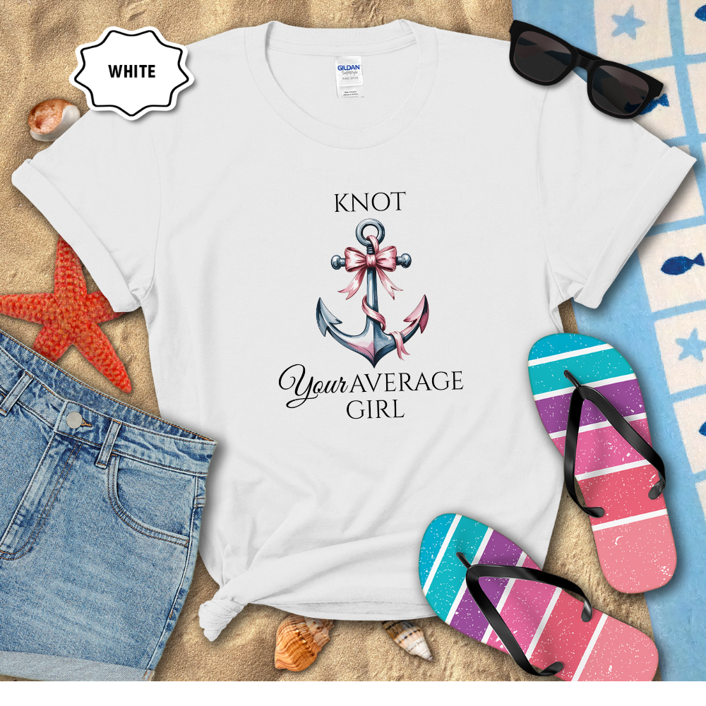 White t-shirt with 'Knot Your Average Girl' design on a beach setting with sunglasses, flip-flops, and denim shorts.