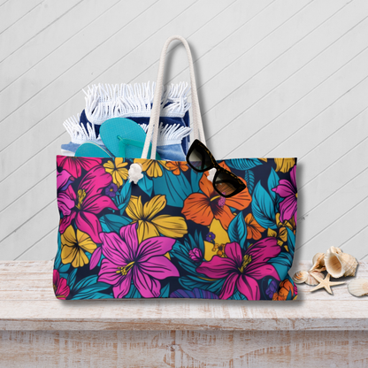 Floral tote bag with sunglasses and flip-flops on a wooden surface