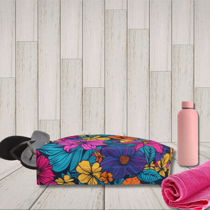 Colorful floral box with a pink water bottle and towel on a wooden surface