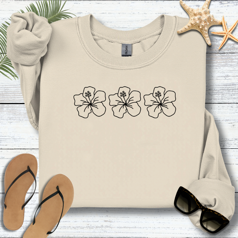 Beige sweatshirt with floral designs on a wooden surface with flip-flops and starfish.