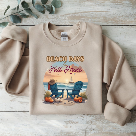 Beige sweatshirt with beach and fall design on a wooden surface