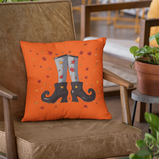 Orange pillow with black boots design on a brown chair