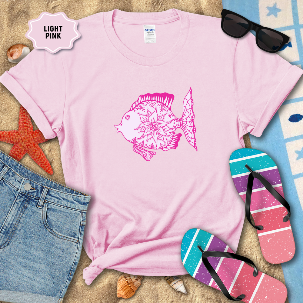 Light pink t-shirt with a fish design, sunglasses, and flip-flops on a sandy background