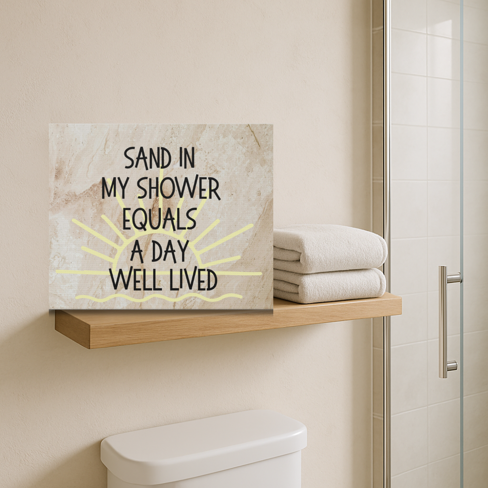 Bathroom with a motivational sign on a shelf, towels stacked, and a shower in the background.