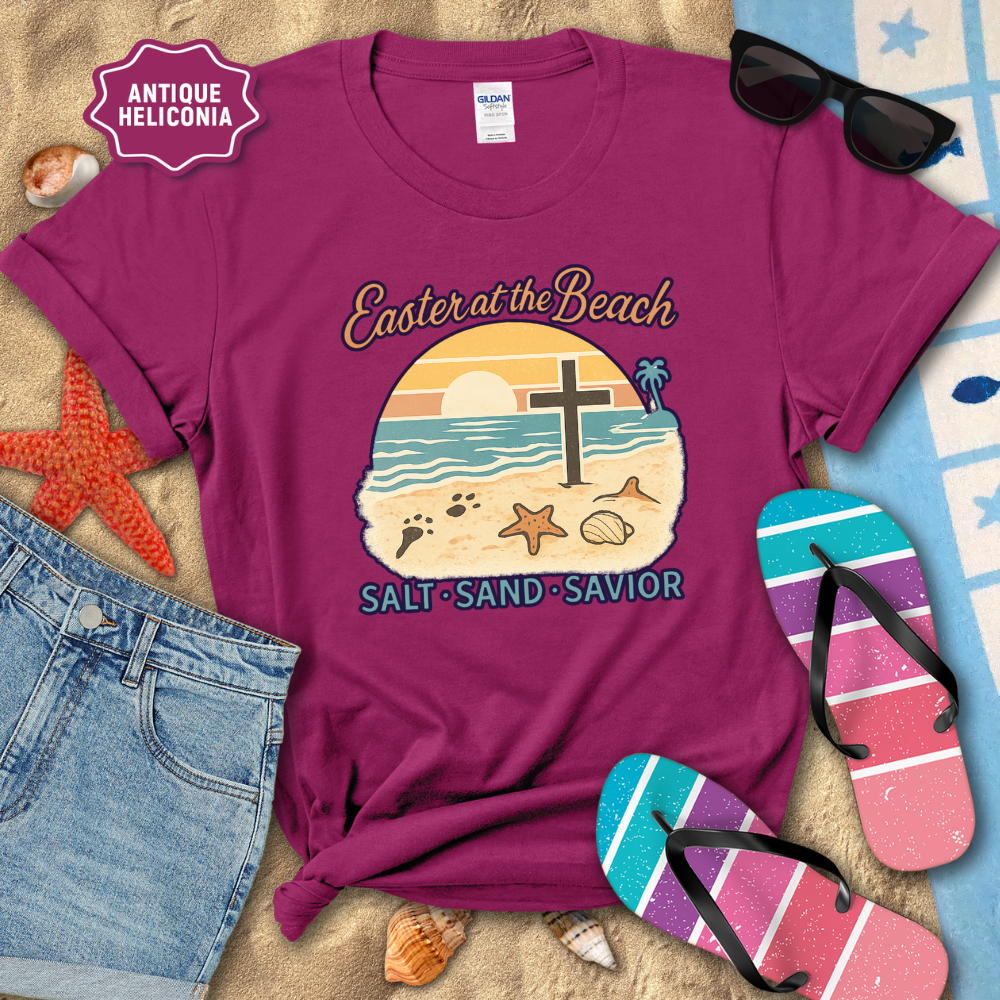 Purple t-shirt with beach-themed design and text, surrounded by beach accessories.