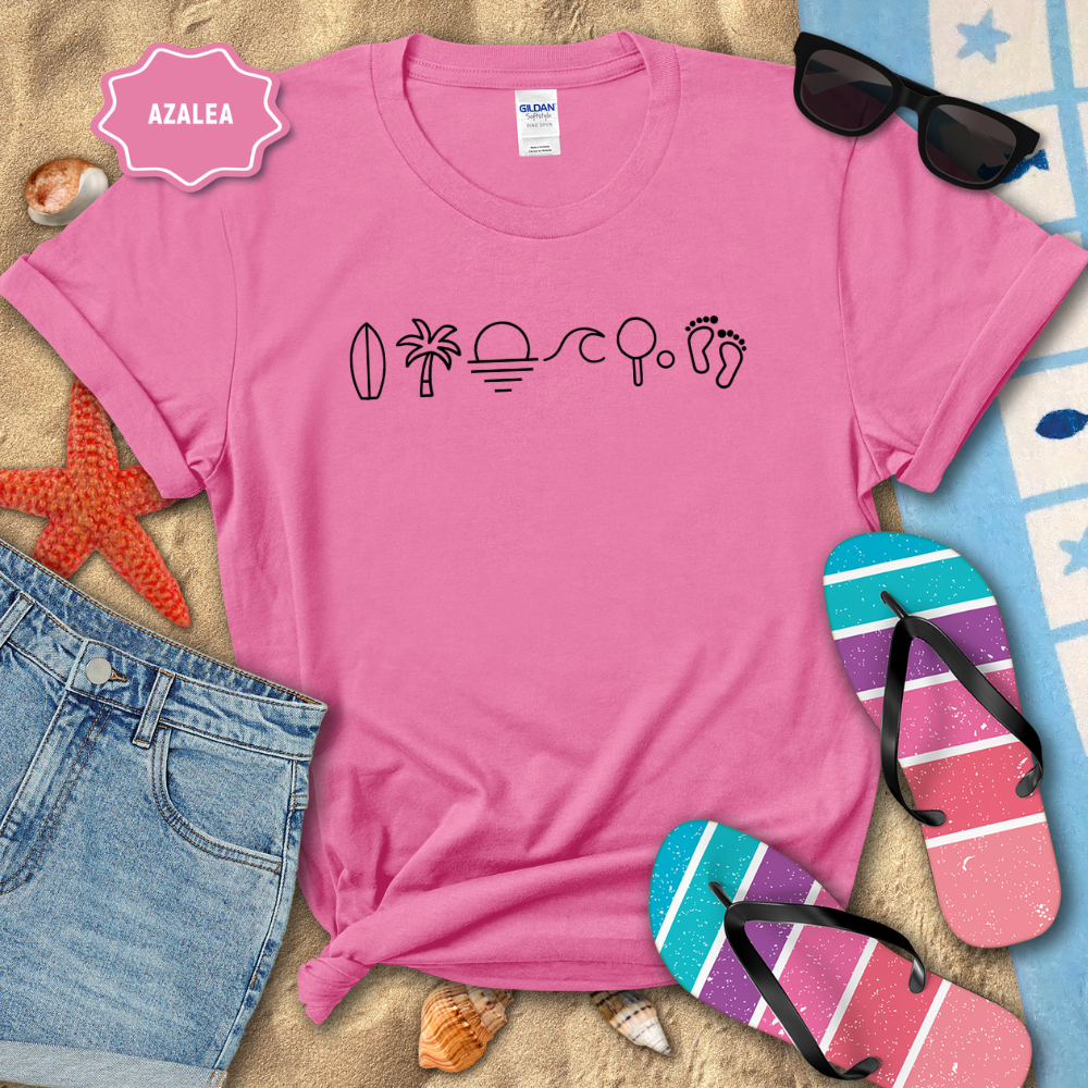 Pink t-shirt with beach-themed icons on a sandy background with flip-flops and sunglasses.