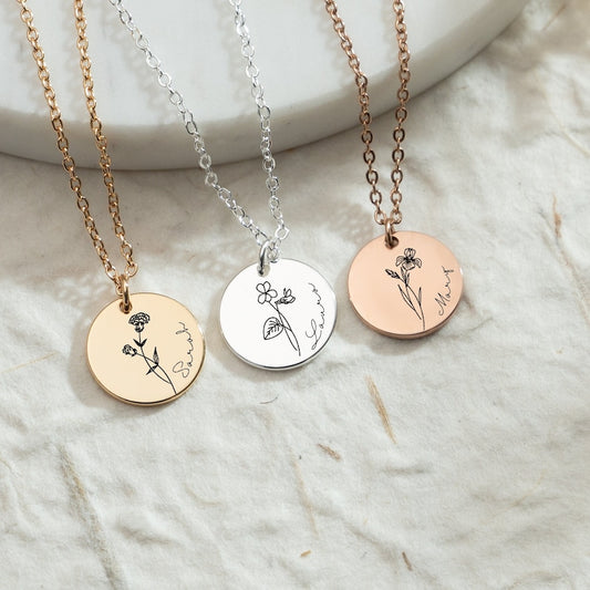 Three necklaces with circular pendants on a marble surface
