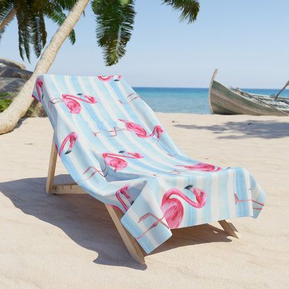Flamingo beach towel with blue and white stripes on lounge chair