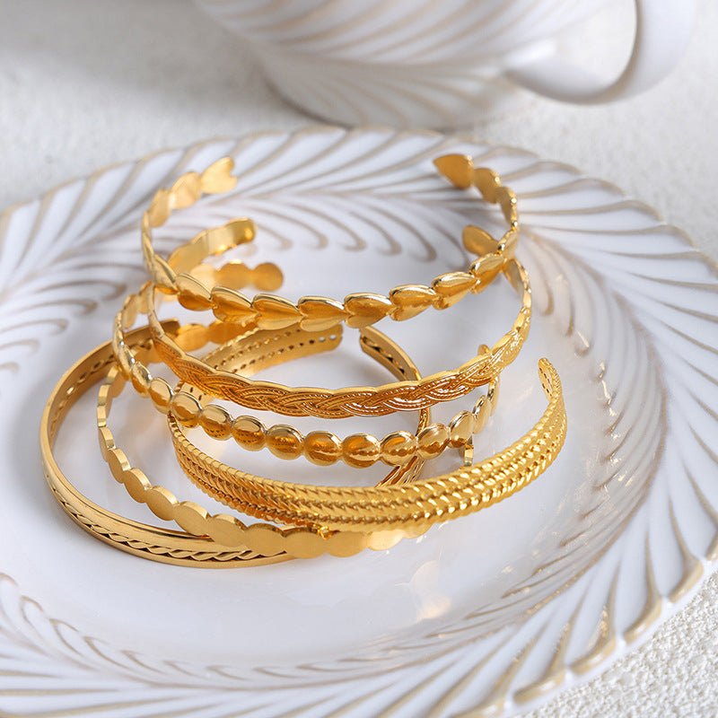 Set of gold bracelets on a decorative white surface