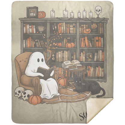 Blanket with ghost reading a book and black cat in front of a bookshelf.