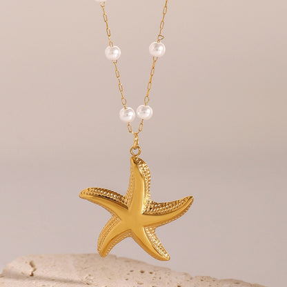 Gold starfish pendant necklace with pearls on a beige background