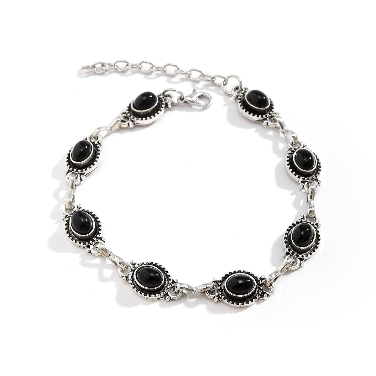 Silver bracelet with black gemstones on a white background
