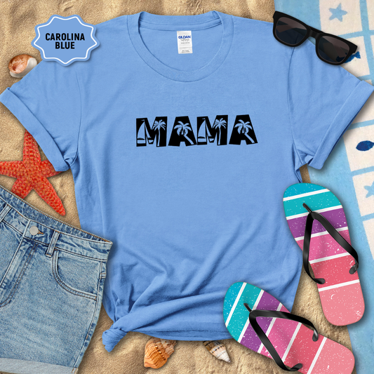 Blue t-shirt with 'MAMA' text on a sandy surface with beach accessories.