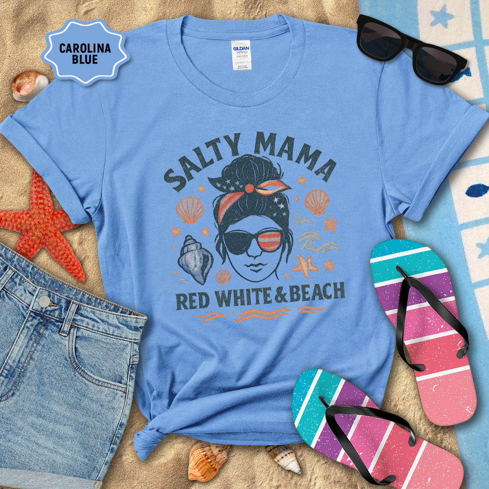 Blue t-shirt with 'Salty Mama Red White & Beach' design on sand with sunglasses and flip-flops.