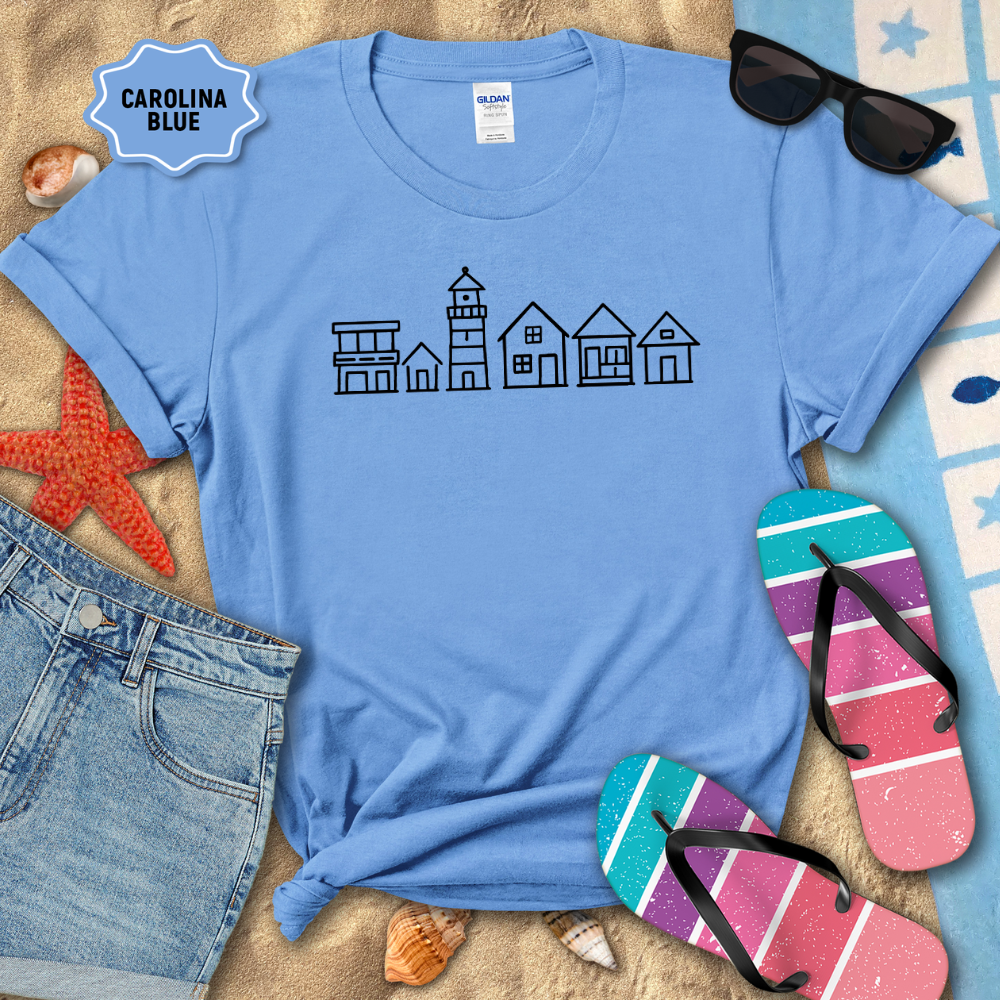 Blue t-shirt with house design, sunglasses, and flip-flops on a sandy background