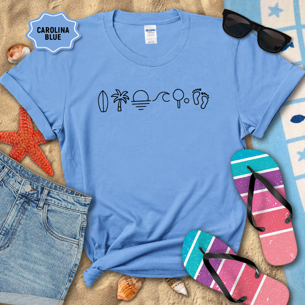Blue t-shirt with beach-themed icons on a sandy background with flip-flops and sunglasses.