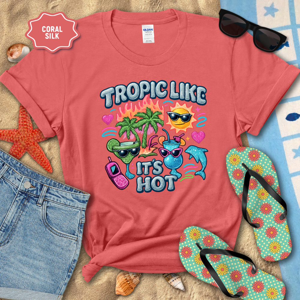 Coral t-shirt with tropical design and beach accessories on sand