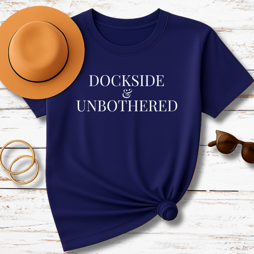 Navy blue t-shirt with 'LOW TIDE, HIGH STANDARDS' text on a wooden surface with accessories.