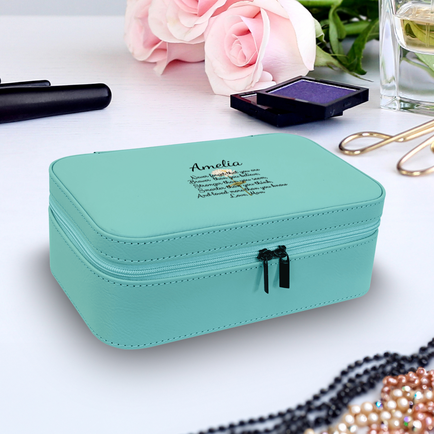 Teal zippered jewelry pouch on a dresser
