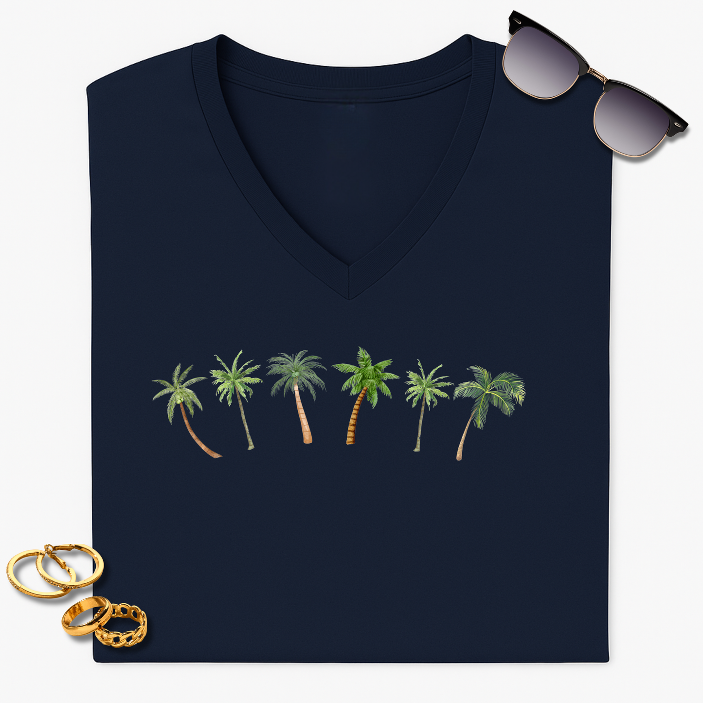 Navy blue V-neck t-shirt with palm tree design, sunglasses, and gold rings on a white background