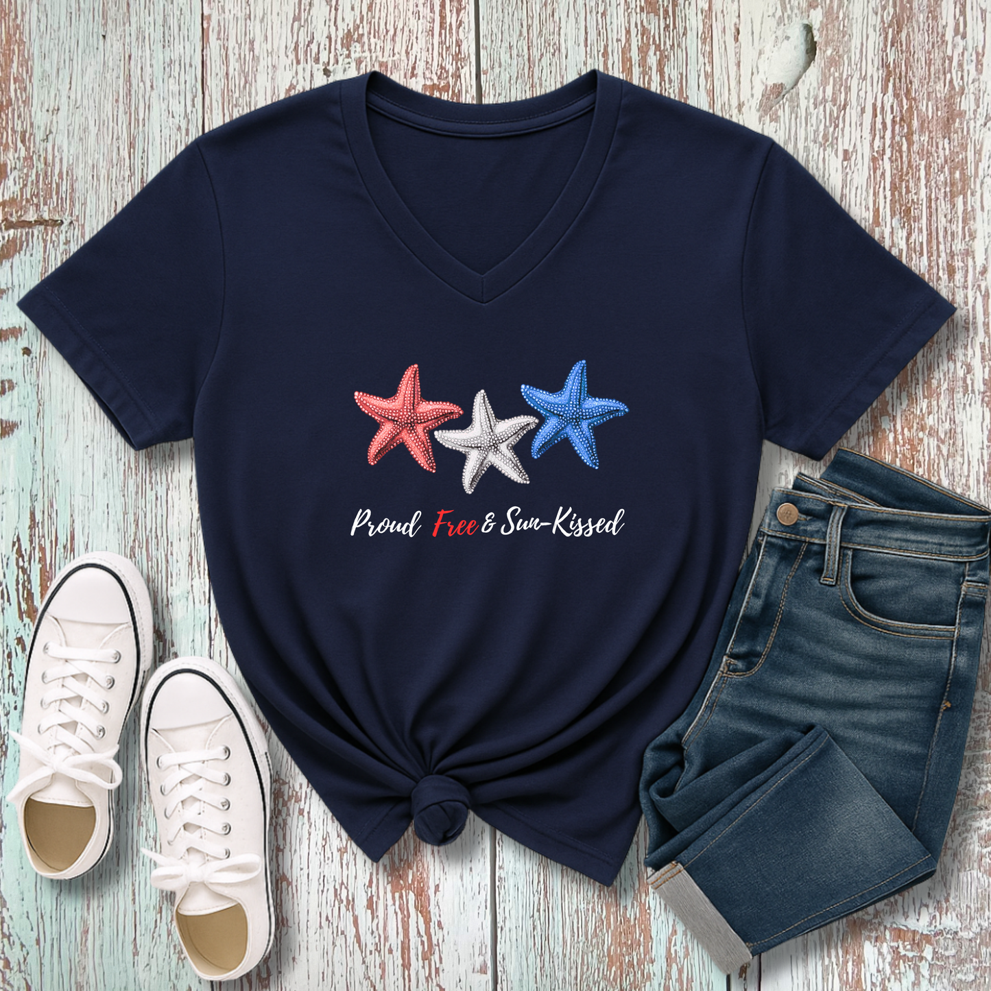 Navy blue t-shirt with star design and text, paired with white sneakers and jeans on a wooden surface.