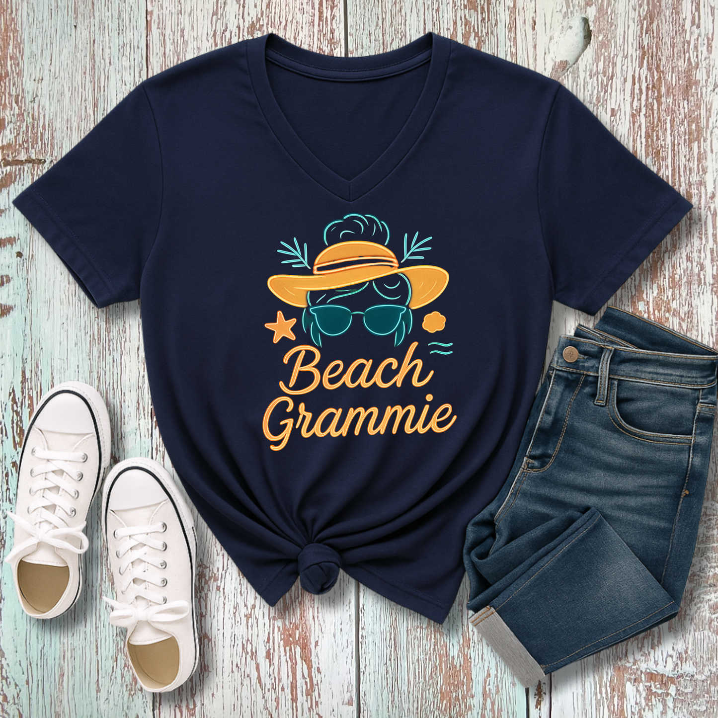 Navy blue t-shirt with flip-flop graphic and text, paired with white sneakers and jeans on a wooden surface.