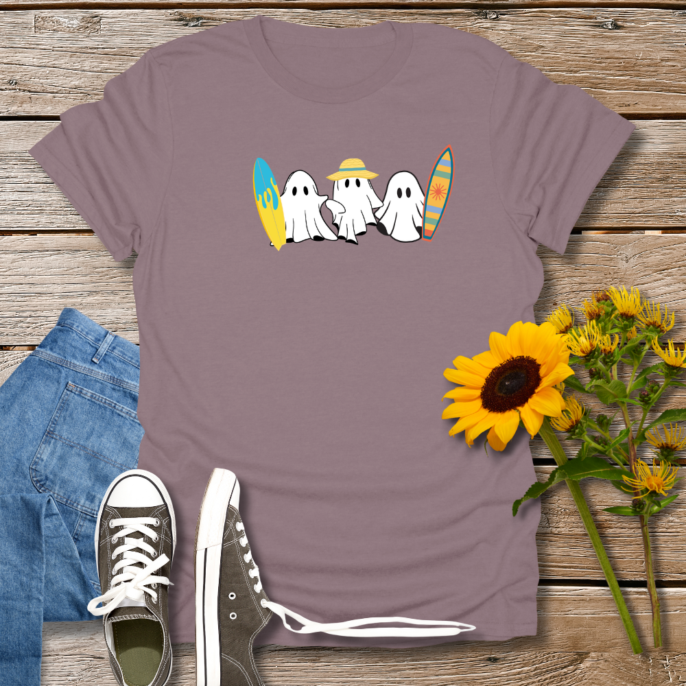 Purple t-shirt with ghost design, jeans, sneakers, and sunflowers on a wooden surface