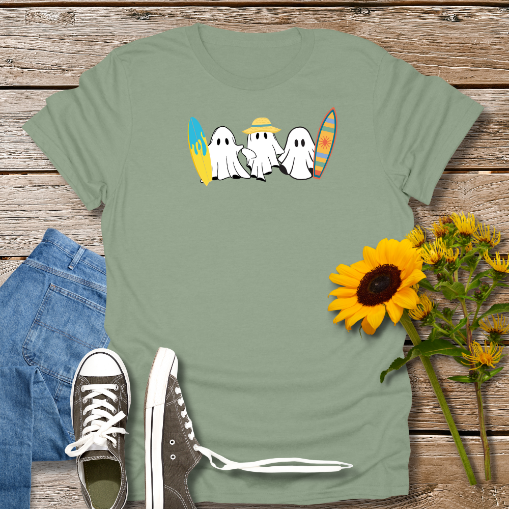 Green t-shirt with ghost design and sunflowers on a wooden surface