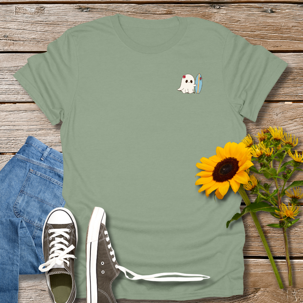 Green t-shirt with cartoon ghost design, sunflower, and jeans on wooden surface