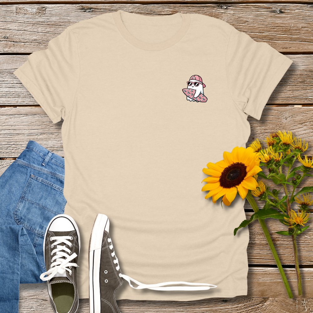 Beige t-shirt with a graphic design, blue jeans, black sneakers, and sunflowers on a wooden surface