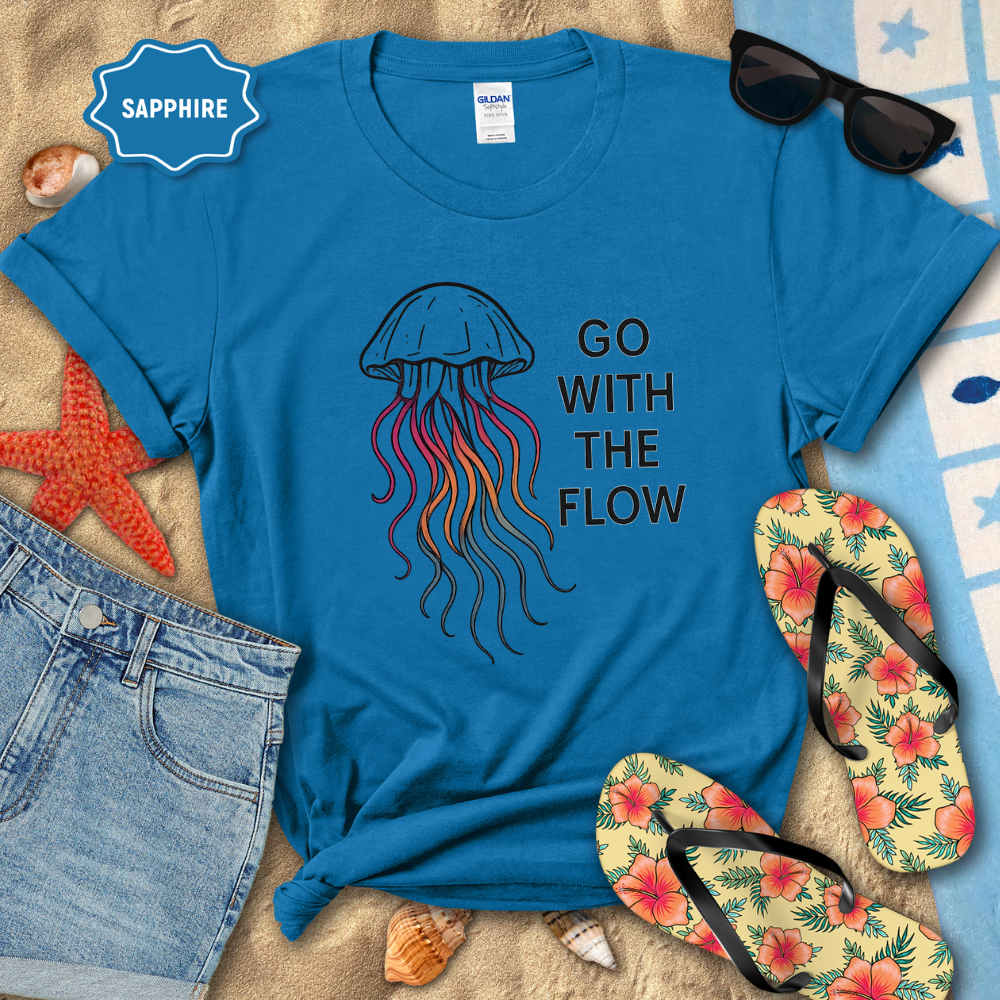 Blue t-shirt with jellyfish graphic and 'Go With The Flow' text on a beach-themed background.