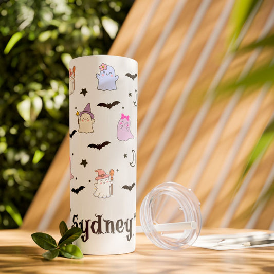 Tumbler with Halloween-themed design and 'Sydney' text on a wooden surface with plants in the background
