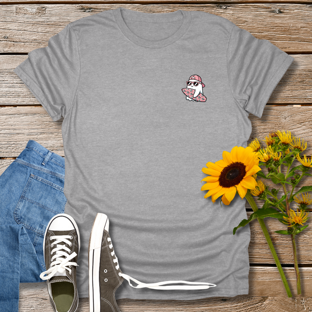 Gray t-shirt with a small graphic on a wooden surface with jeans and sneakers.