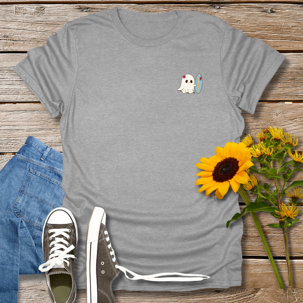 Gray t-shirt with a small graphic on a wooden surface with jeans and sunflowers.
