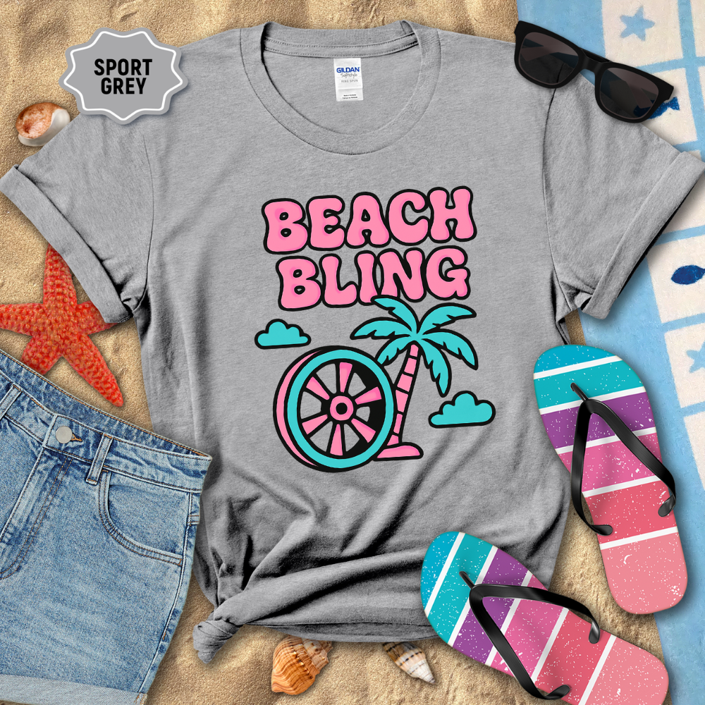 Gray t-shirt with 'Beach Bling' design on a sandy background with beach accessories.