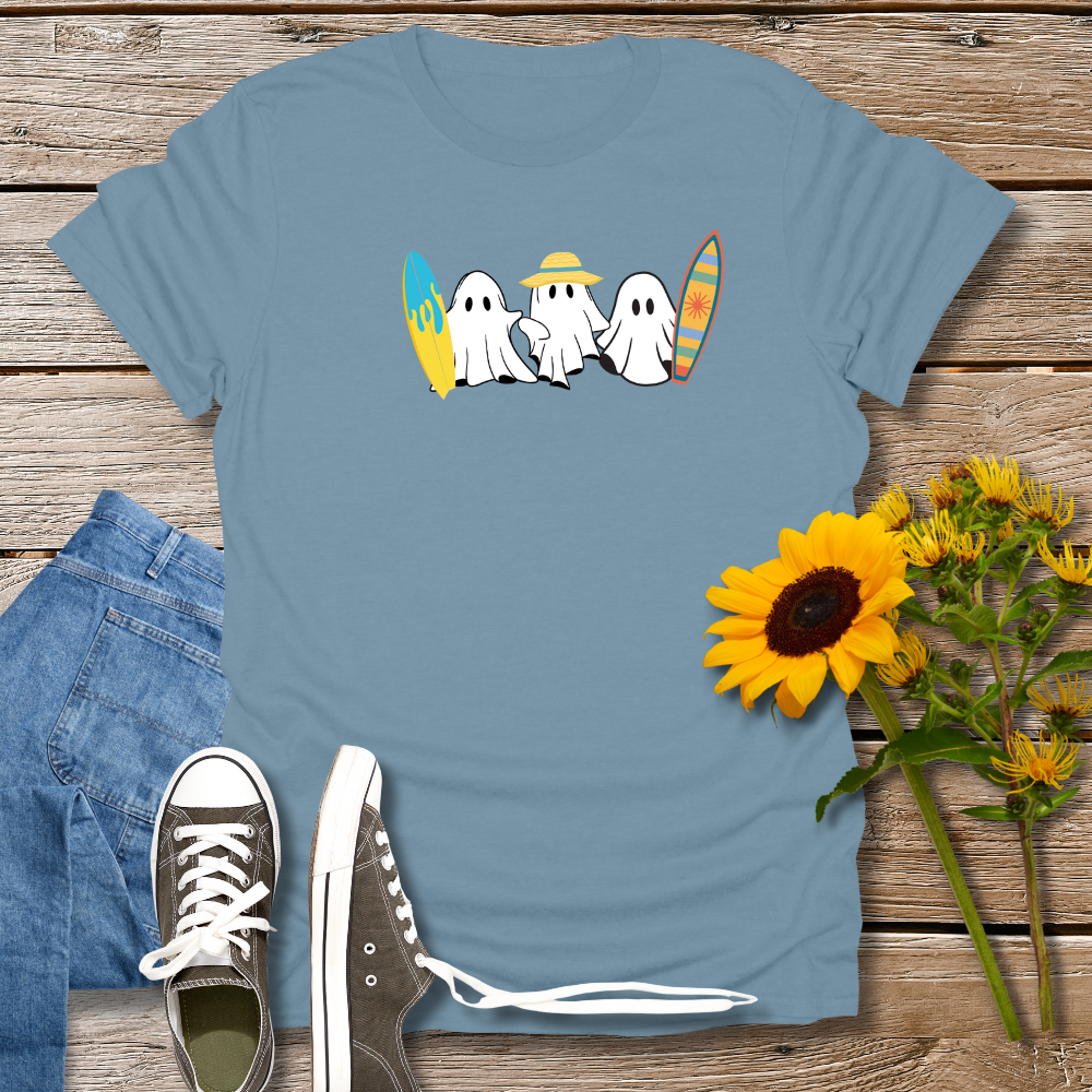 Blue t-shirt with ghost design, jeans, sneakers, and sunflowers on a wooden surface