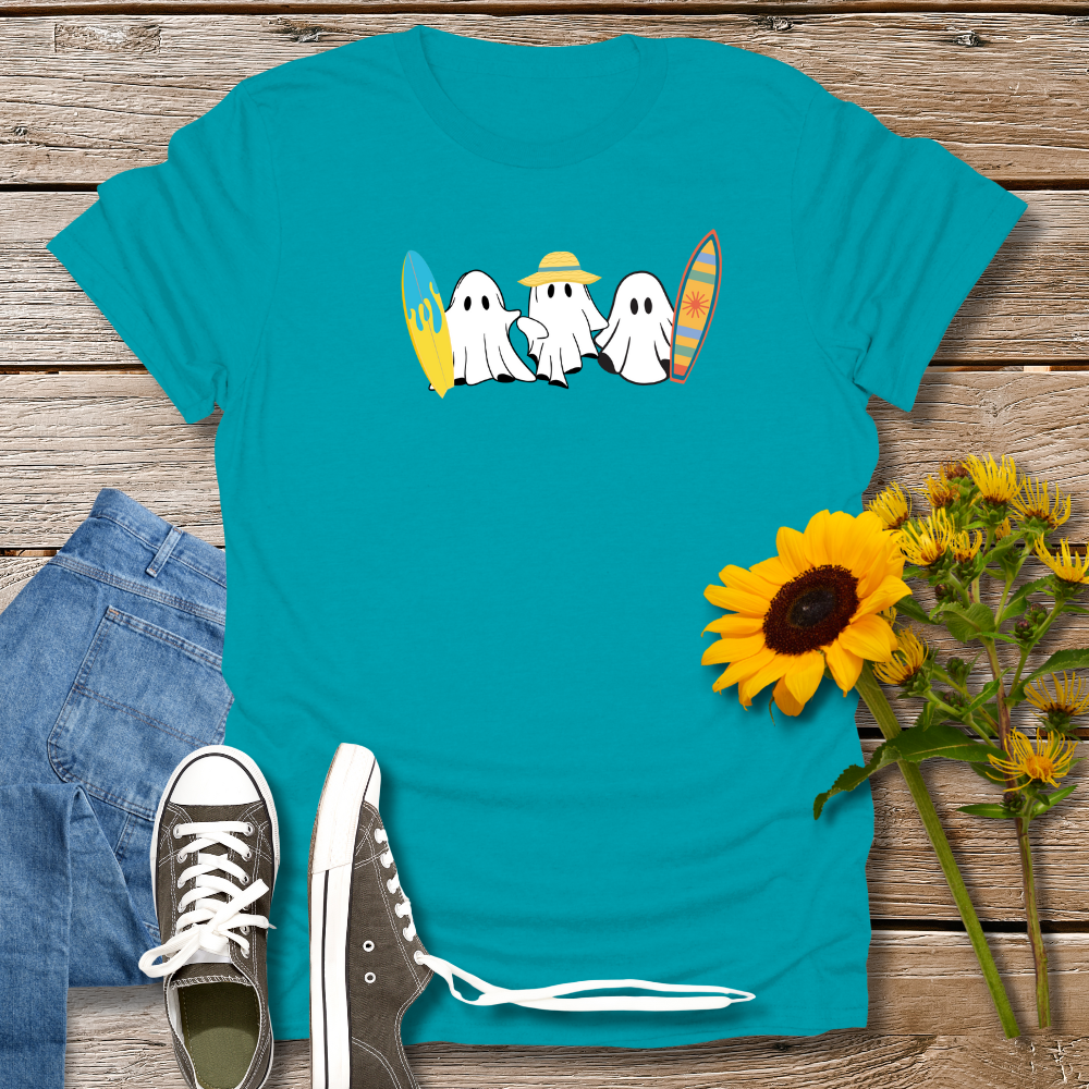 Teal t-shirt with ghost design, jeans, sneakers, and sunflowers on a wooden surface