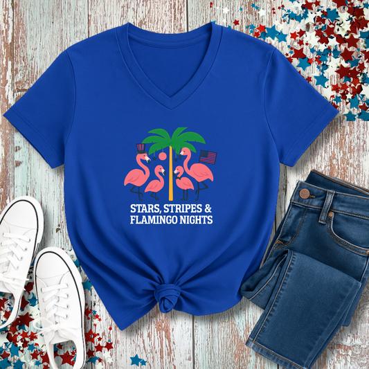 Blue t-shirt with flamingo and palm tree design on a wooden surface with jeans and sneakers.