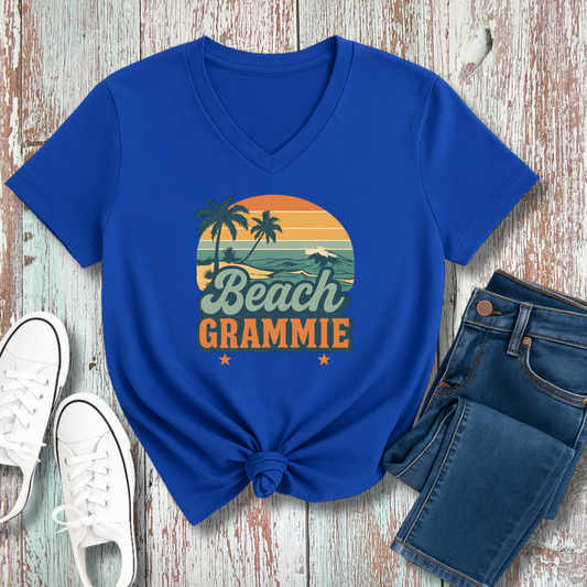 Blue t-shirt with 'Beach Grammie' design on a wooden surface with jeans and sneakers.
