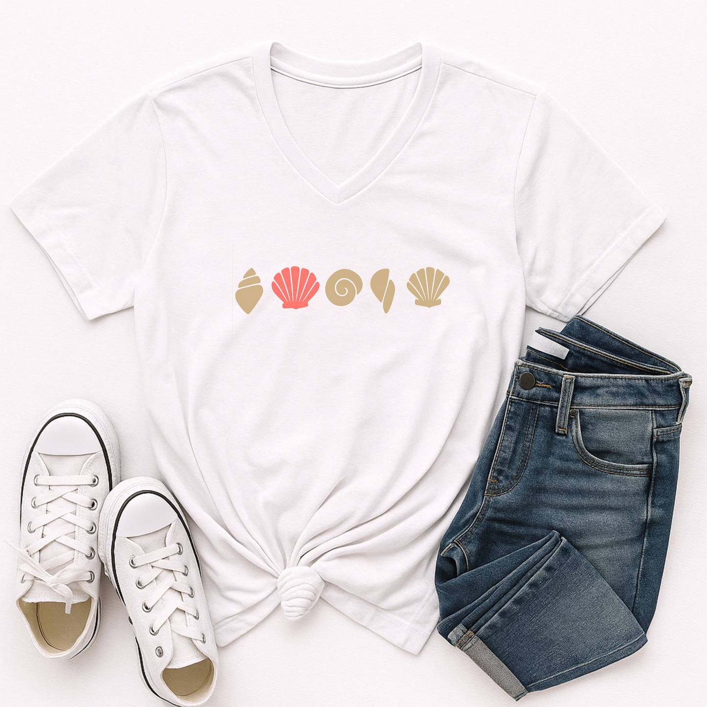 White t-shirt with shell design, white sneakers, and blue jeans on a white background