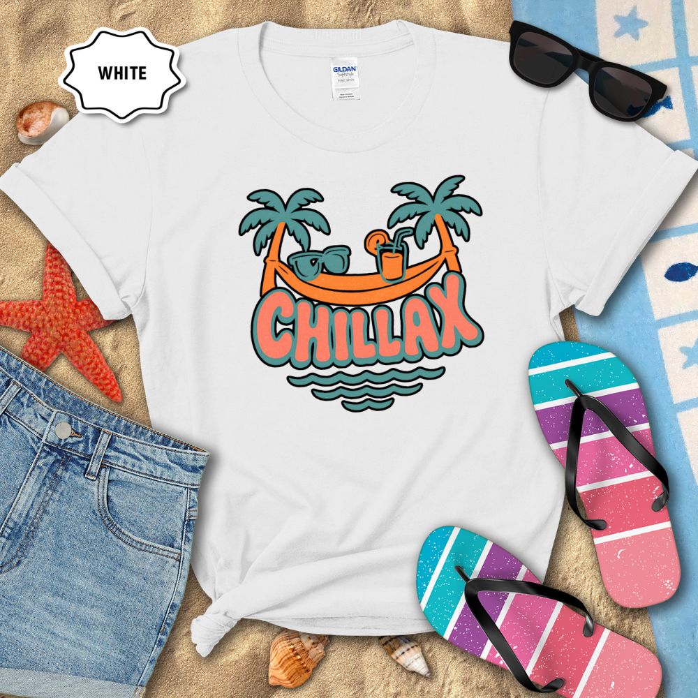 White t-shirt with 'Chillax' graphic design on a beach setting with sunglasses, flip-flops, and denim shorts.