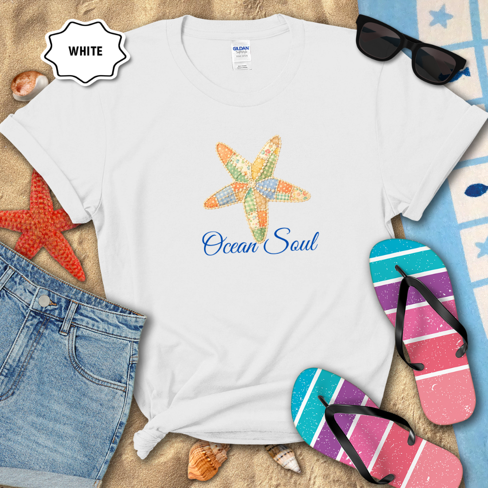 White t-shirt with starfish design and 'Ocean Soul' text on a beach-themed background with sunglasses, flip-flops, and starfish.