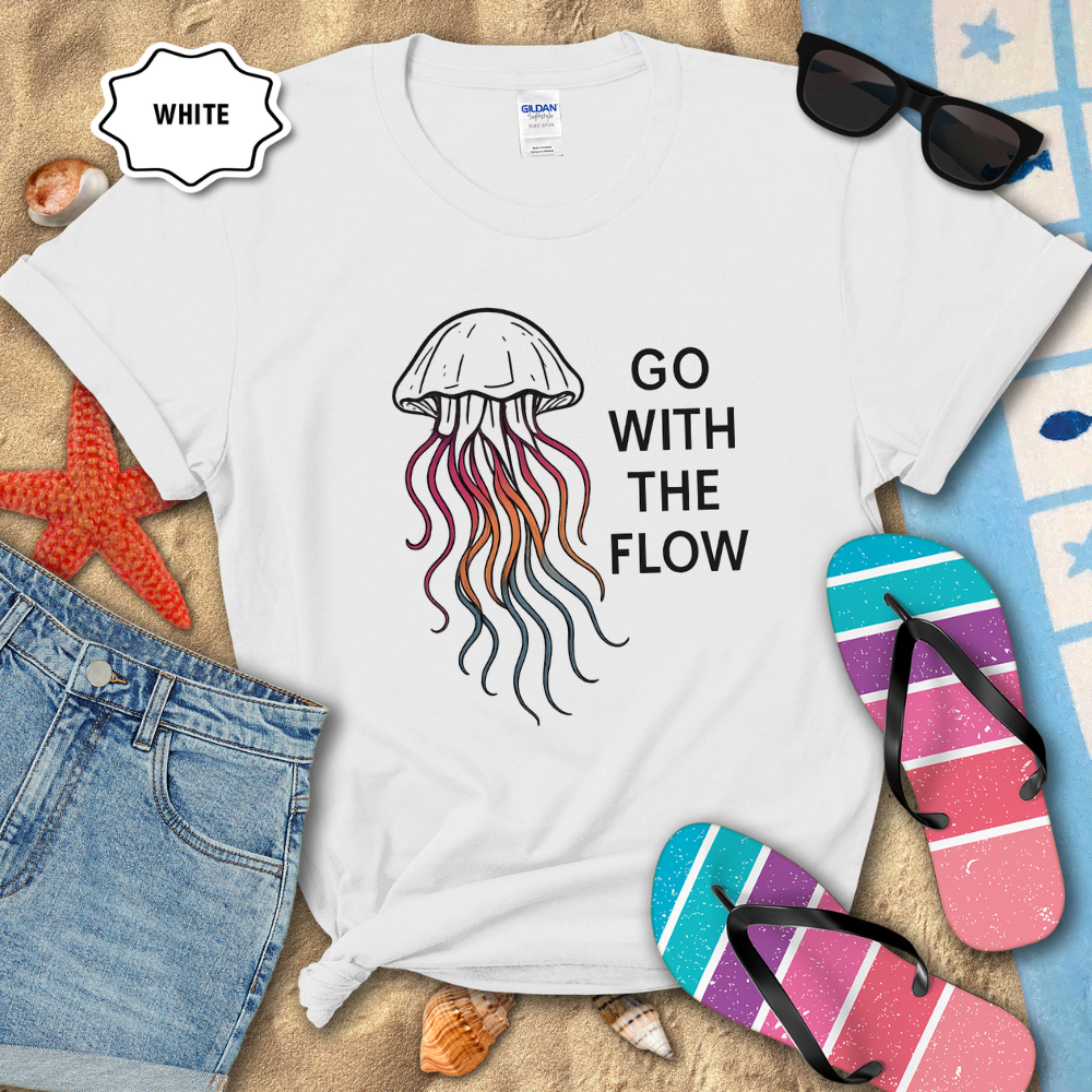 White t-shirt with jellyfish design and 'Go With The Flow' text on a beach setting.